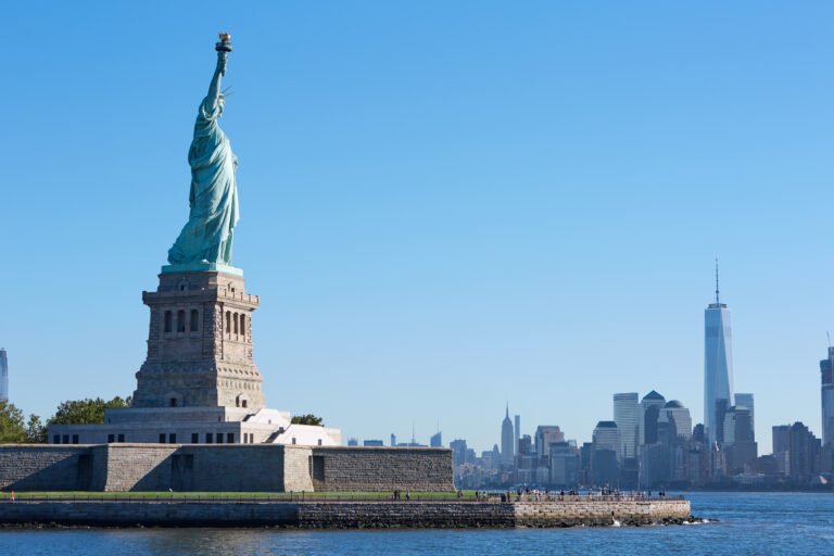 Statue of Liberty island and New York city skyline in a sunny da